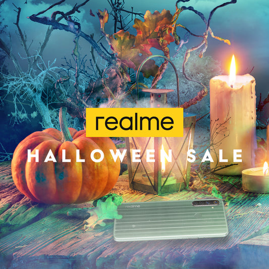 Halloween sale advertisement featuring Realme smartphone, pumpkin, lantern, and candles on wooden table